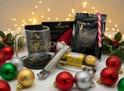 Tea-making set with a mug, tea leaves, and accessories on a white surface.